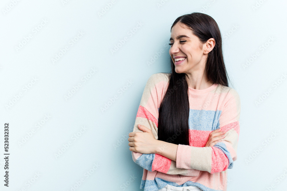 Young caucasian woman isolated on blue background smiling confident with crossed arms. Young caucasian woman isolated on blue background smiling confident with crossed arms.