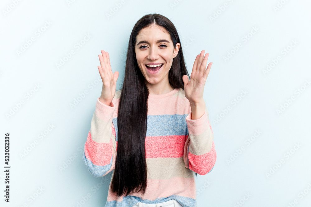 Young caucasian woman isolated on blue background laughs out loudly keeping hand on chest. Young caucasian woman isolated on blue background laughs out loudly keeping hand on chest.