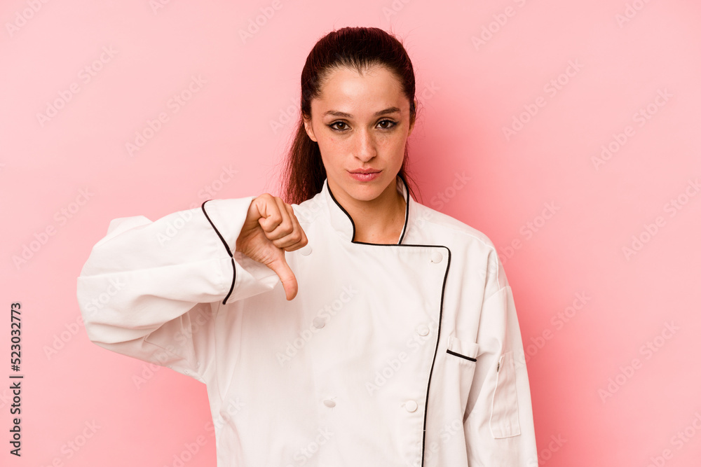 Young chef caucasian woman holding a spaghettis jar isolated on pink background showing a dislike gesture, thumbs down. Disagreement concept. Young chef caucasian woman holding a spaghettis jar isolated on pink background showing a dislike gesture, thumbs down. Disagreement concept.