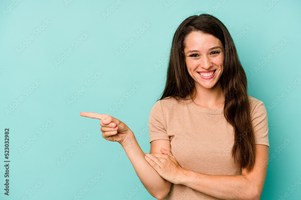 Young caucasian woman isolated on blue background smiling cheerfully pointing with forefinger away. Young caucasian woman isolated on blue background smiling cheerfully pointing with forefinger away.