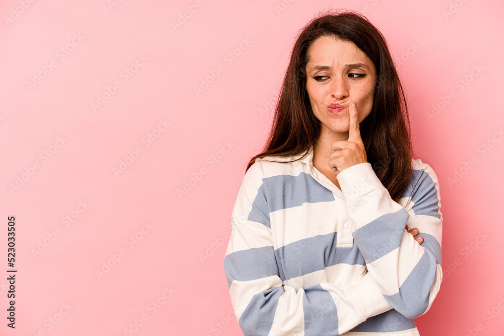 Young caucasian woman isolated on pink background looking sideways with doubtful and skeptical expression. Young caucasian woman isolated on pink background looking sideways with doubtful and skeptical expression.