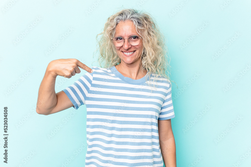 Middle age caucasian woman isolated on blue background person pointing by hand to a shirt copy space, proud and confident Middle age caucasian woman isolated on blue background person pointing by hand to a shirt copy space, proud and confident