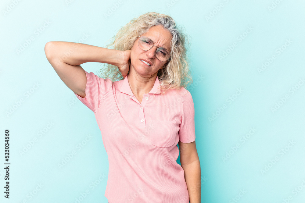 Middle age caucasian woman isolated on blue background having a neck pain due to stress, massaging and touching it with hand.