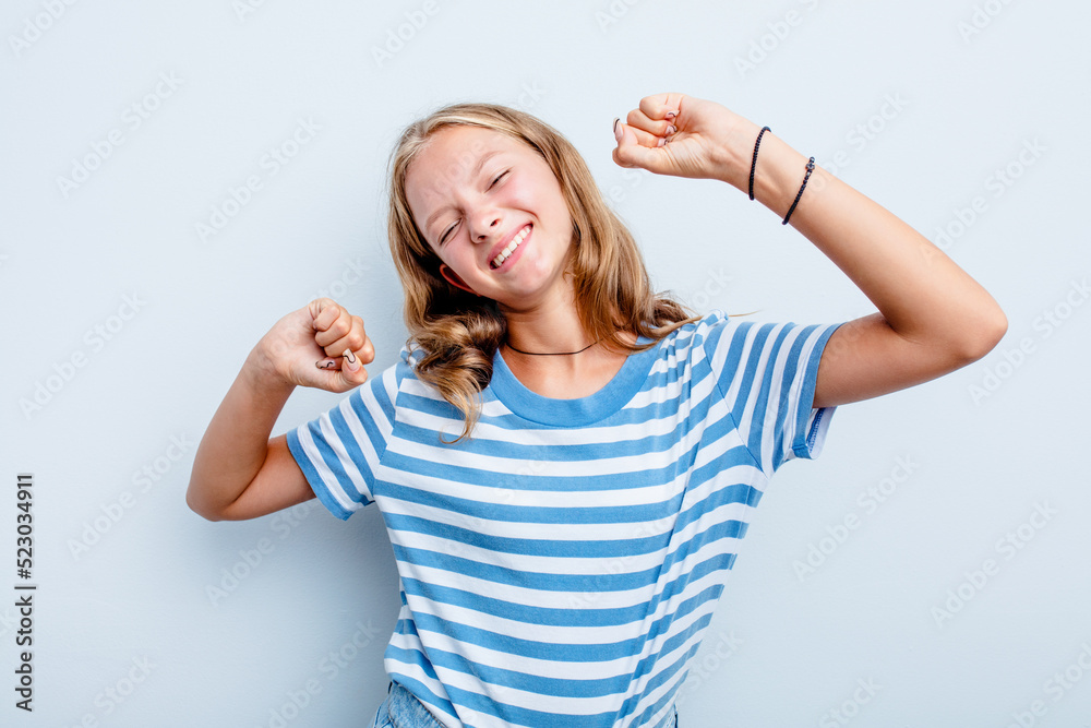 Fototapeta premium Caucasian teen girl isolated on blue background celebrating a special day, jumps and raise arms with energy.