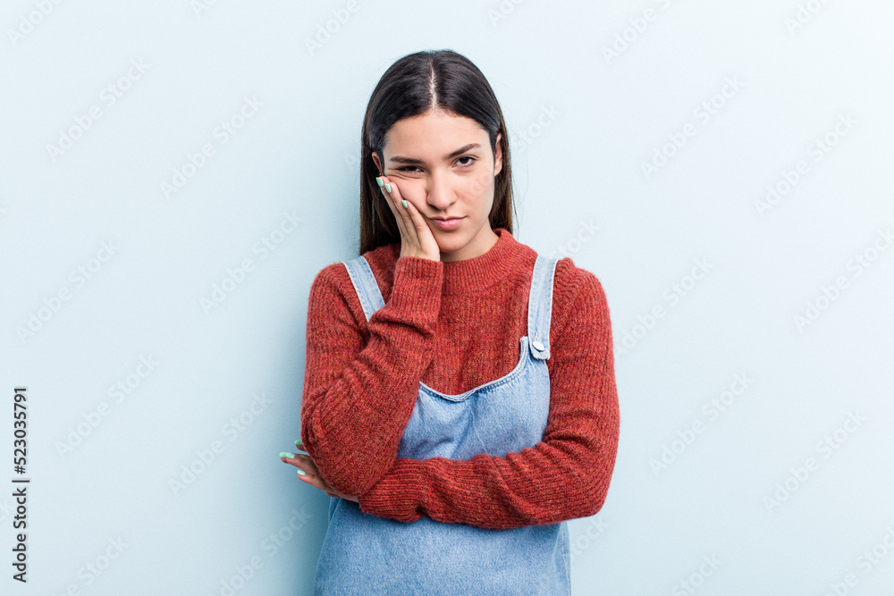 Young caucasian woman isolated on blue background who is bored, fatigued and need a relax day. Young caucasian woman isolated on blue background who is bored, fatigued and need a relax day.