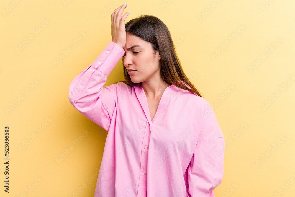 Young caucasian woman isolated on yellow background forgetting something, slapping forehead with palm and closing eyes. Young caucasian woman isolated on yellow background forgetting something, slapping forehead with palm and closing eyes.
