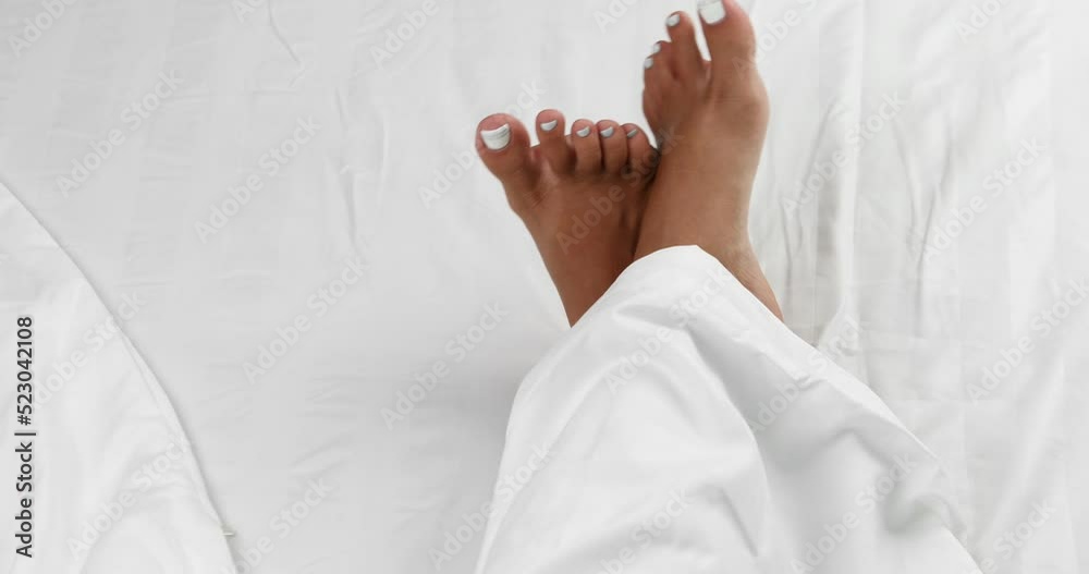 female legs in bed top view, white bedding female legs in bed top view, white bedding