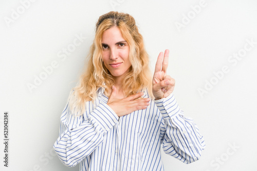 Young caucasian woman isolated on white background taking an oath, putting hand on chest.