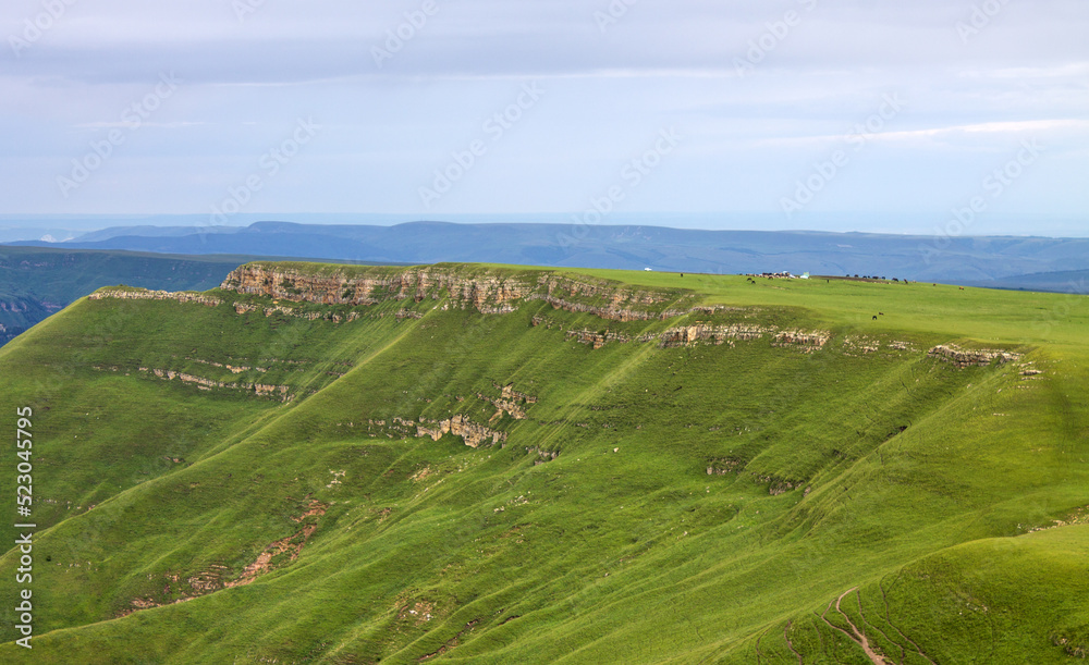 Beautiful landscape - panoramic view of green mountains and hills blurred in morning haze from bermamyt plateau in karachay-cherkessia Russia and copy space Beautiful landscape - panoramic view of green mountains and hills blurred in morning haze from bermamyt plateau in karachay-cherkessia Russia and copy space