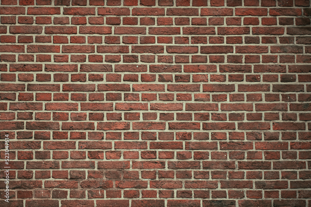 Obraz premium Brick wall background. Pattern brown color design decorative uneven cracked real stone wall surface with cement. Dry brick wall as seamless background