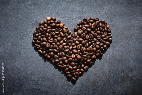 Roasted coffee beans in the shape of a heart on a gray background, love coffee