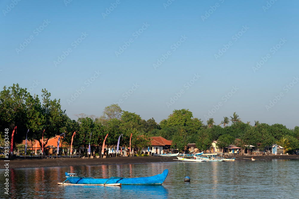 Jukung, traditional Indonesian boat with Pemuteran village in the background