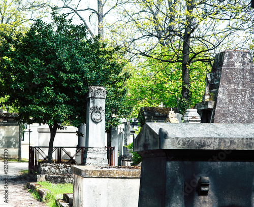 Tombstones in cemetery at dusk, gothic style crosses Paris