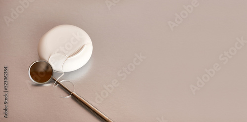 Dental mirror and dental floss on a gray background. Dental care.