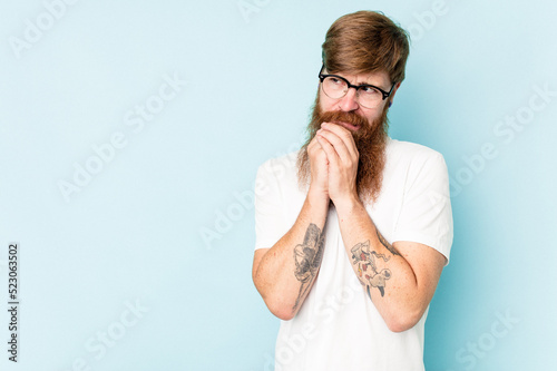 Fototapeta Naklejka Na Ścianę i Meble -  Young caucasian red-haired man isolated on blue background making up plan in mind, setting up an idea.