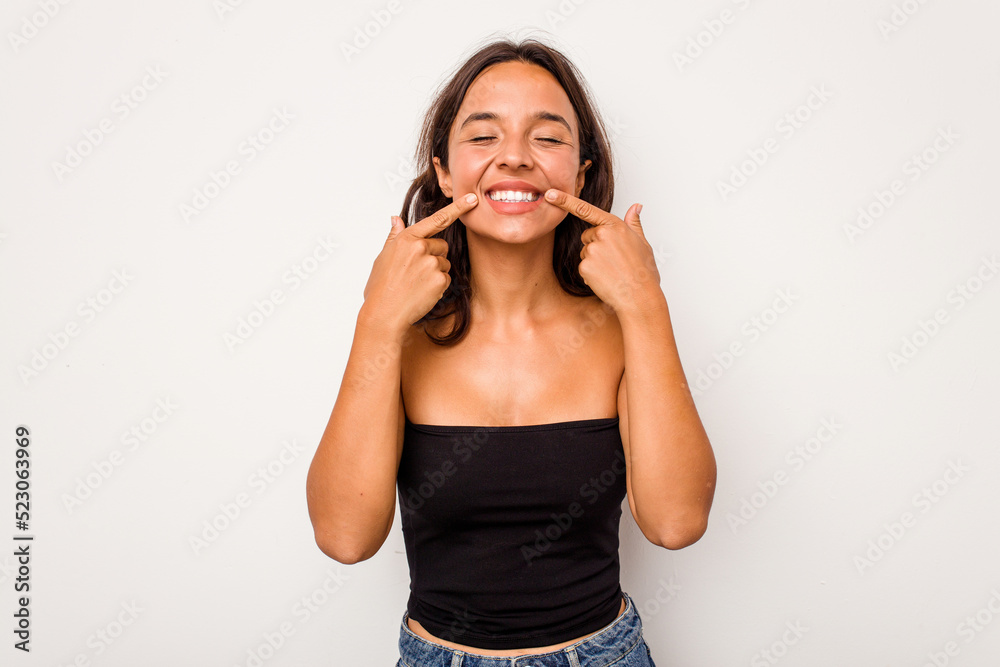 Young hispanic woman isolated on white background smiles, pointing fingers at mouth. Young hispanic woman isolated on white background smiles, pointing fingers at mouth.