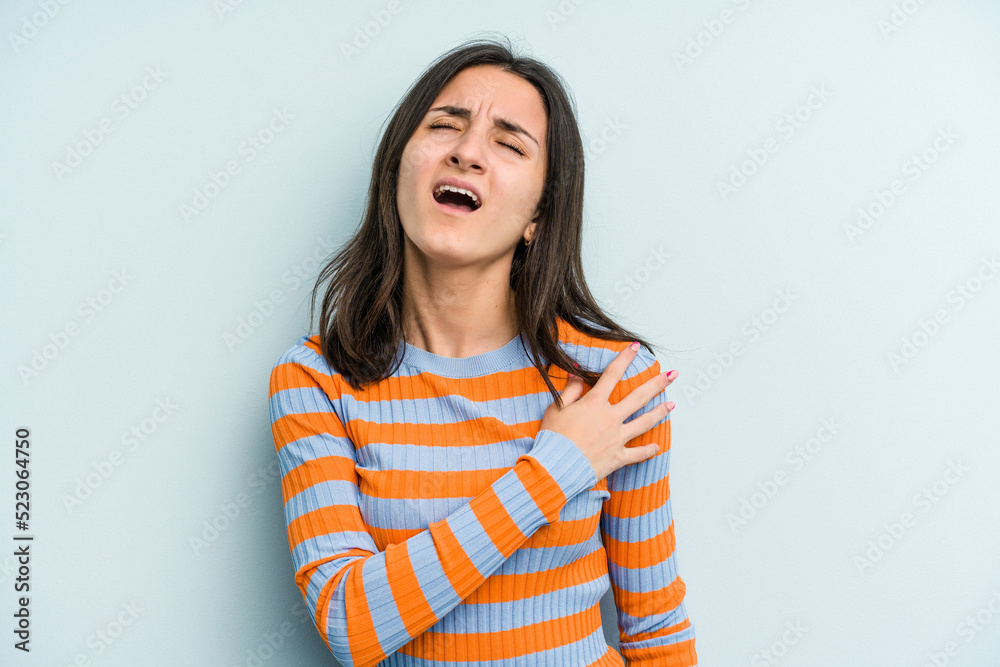 Young caucasian woman isolated on blue background having a shoulder pain. Young caucasian woman isolated on blue background having a shoulder pain.