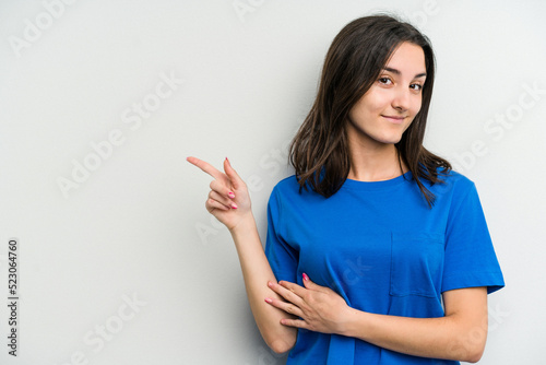 Young caucasian woman isolated on white background smiling cheerfully pointing with forefinger away.