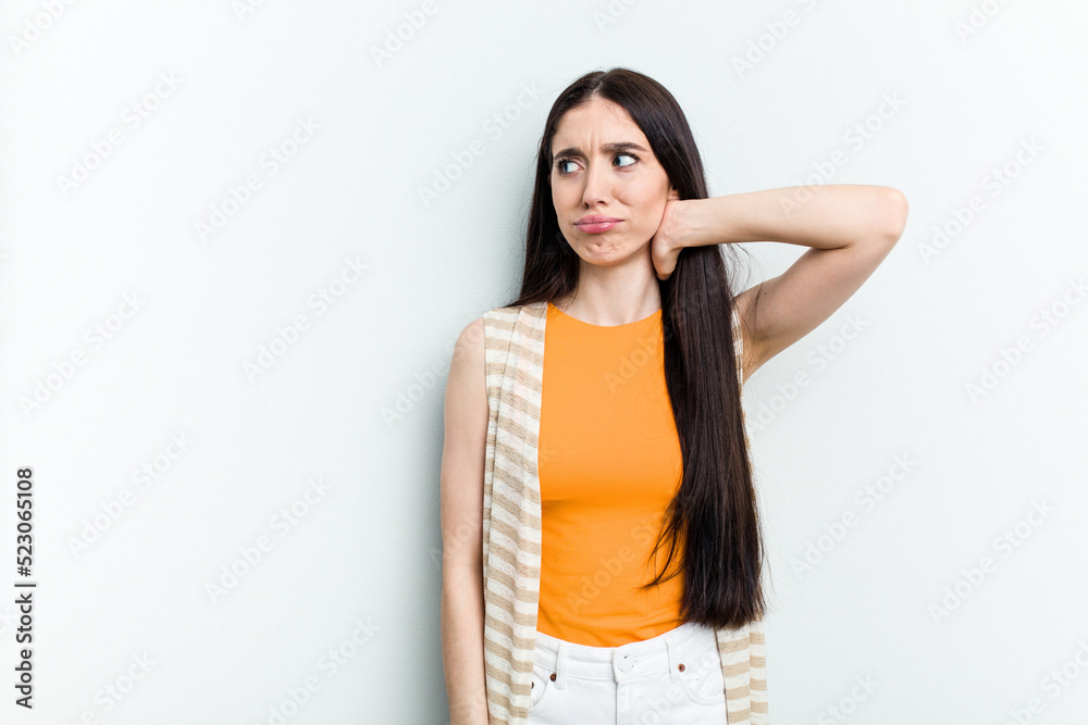 Young caucasian woman isolated on white background touching back of head, thinking and making a choice. Young caucasian woman isolated on white background touching back of head, thinking and making a choice.