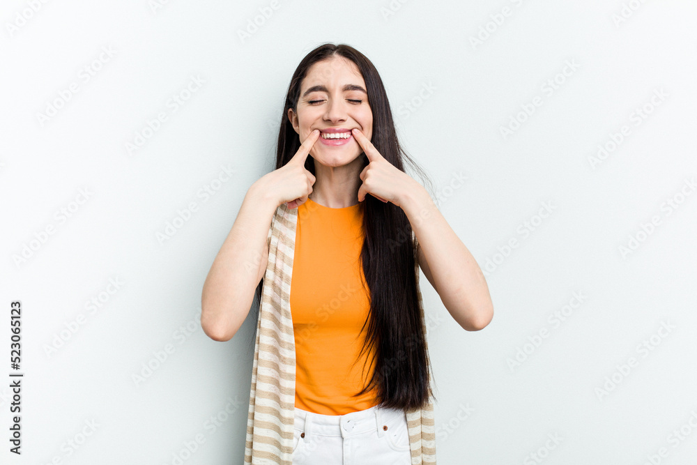 Young caucasian woman isolated on white background smiles, pointing fingers at mouth. Young caucasian woman isolated on white background smiles, pointing fingers at mouth.