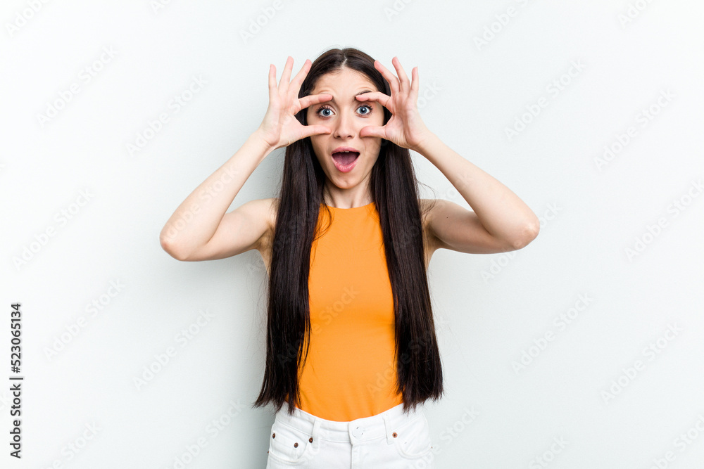 Young caucasian woman isolated on white background keeping eyes opened to find a success opportunity.