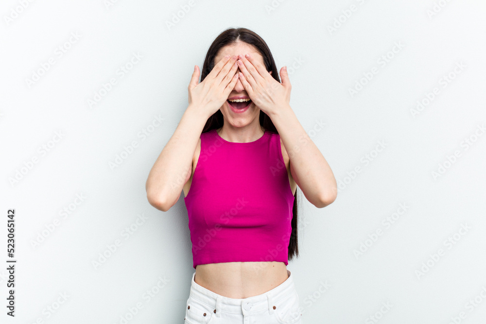 Young caucasian woman isolated on white background covers eyes with hands, smiles broadly waiting for a surprise. Young caucasian woman isolated on white background covers eyes with hands, smiles broadly waiting for a surprise.