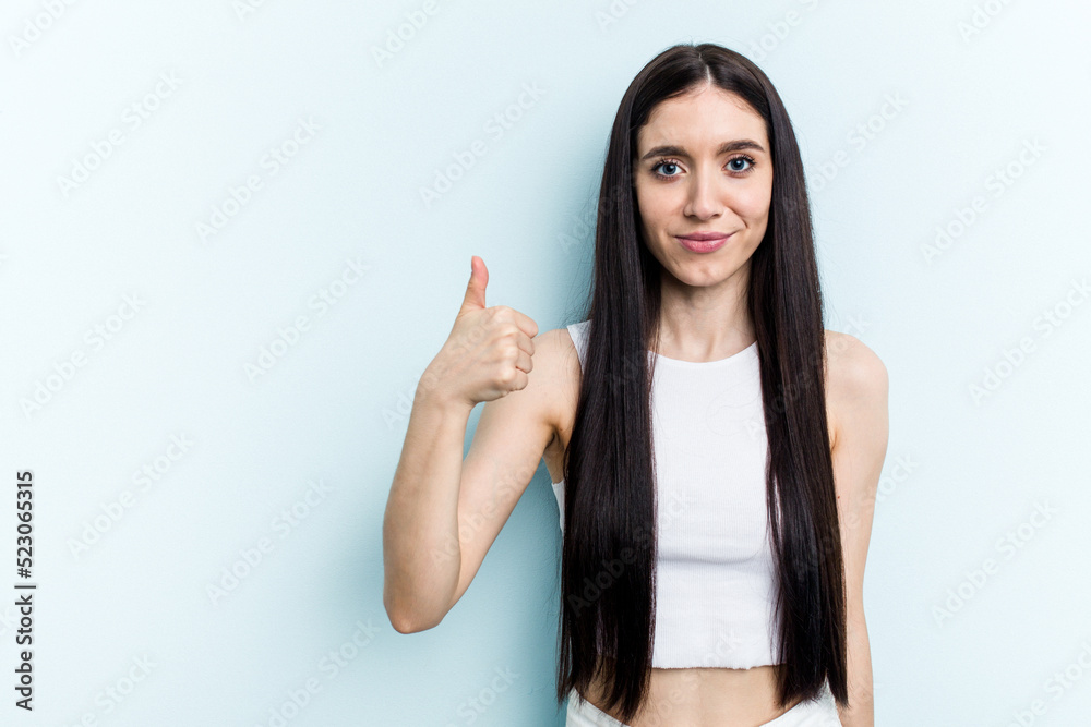 Young caucasian woman isolated on blue background smiling and raising thumb up Young caucasian woman isolated on blue background smiling and raising thumb up