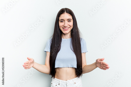 Young caucasian woman isolated on white background holding something with both hands, product presentation.