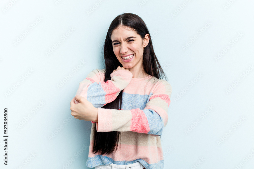 Young caucasian woman isolated on blue background massaging elbow, suffering after a bad movement. Young caucasian woman isolated on blue background massaging elbow, suffering after a bad movement.