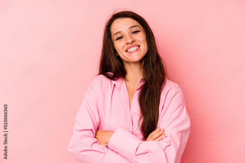 Young caucasian woman isolated on pink background who feels confident, crossing arms with determination.