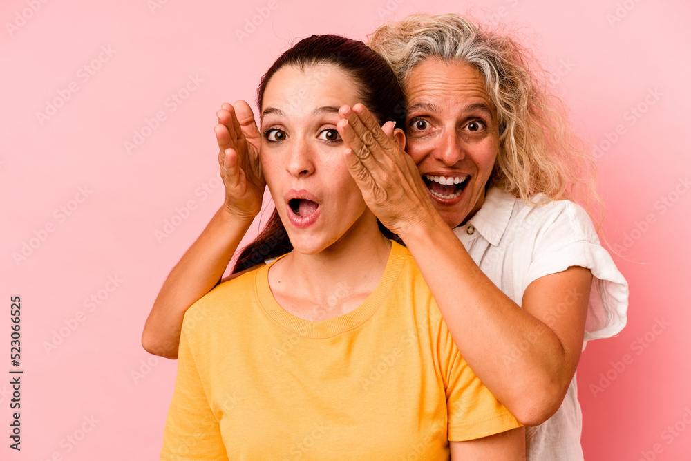 Caucasian mom and daughter isolated on pink background Caucasian mom and daughter isolated on pink background