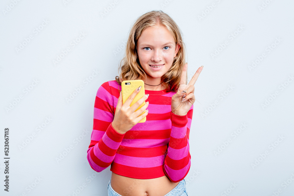 Caucasian teen girl holding mobile phone isolated on blue background showing number two with fingers. Caucasian teen girl holding mobile phone isolated on blue background showing number two with fingers.