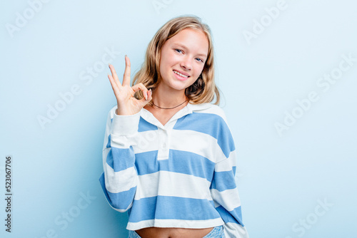 Caucasian teen girl isolated on blue background cheerful and confident showing ok gesture.