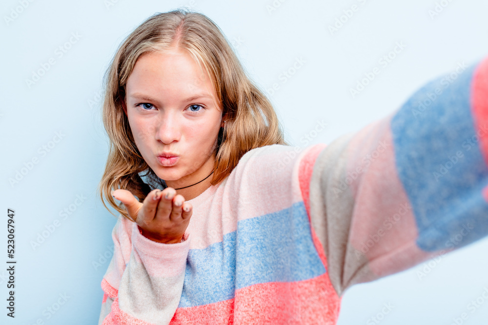 Caucasian teen woman doing a selfie isolated on blue background Caucasian teen woman doing a selfie isolated on blue background