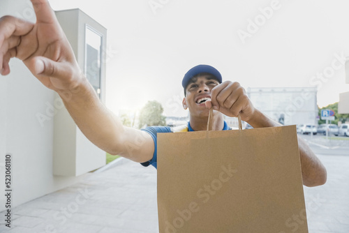 Tableau sur toile POV African delivery man delivering fast food with thermal backpack while ringin