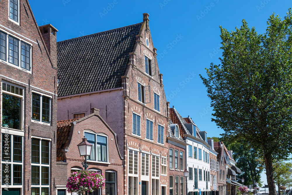 Row of canal houses along a canal in the dutch historic city of Hoorn.