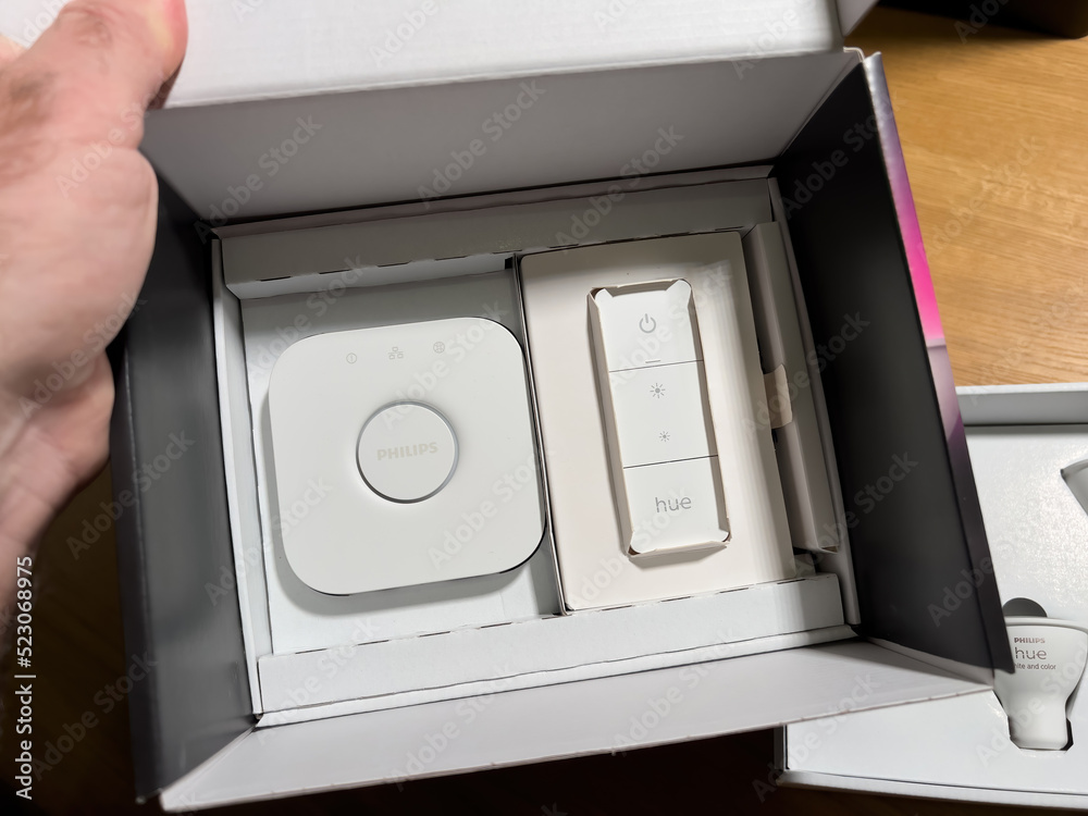 Paris, France - Dec 14, 2021: POV male hand unboxing set of new Philips Hue  Bridge with remote control switch and three GU10 bulbs with white and color  capabilities foto de Stock | Adobe Stock