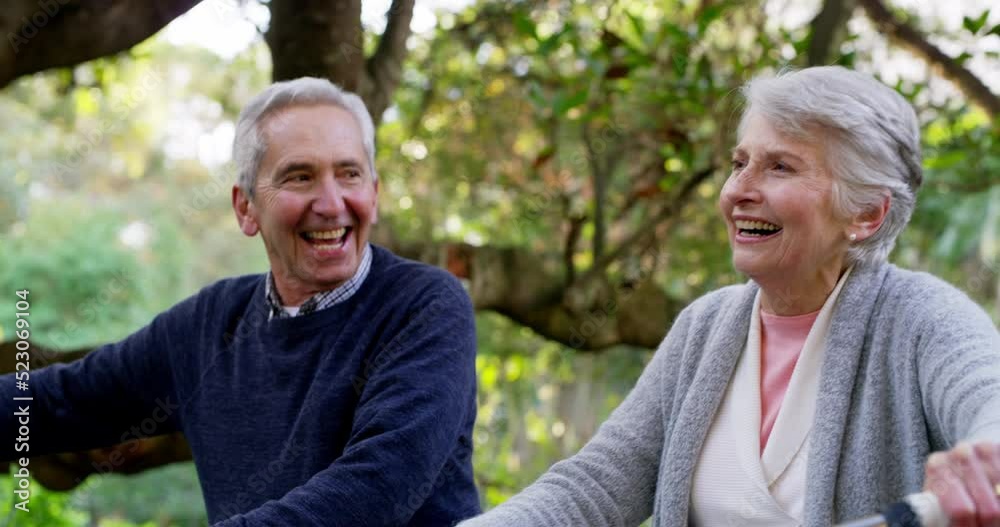 Happy, active and retired senior couple enjoying a walk with their bicycles through a park while laughing and having fun. Happy elderly man and woman talking and enjoying a active date outdoors Happy, active and retired senior couple enjoying a walk with their bicycles through a park while laughing and having fun. Happy elderly man and woman talking and enjoying a active date outdoors