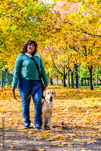 Young woman with cute labrador retriever dog at the park on autumn © ihorbondarenko