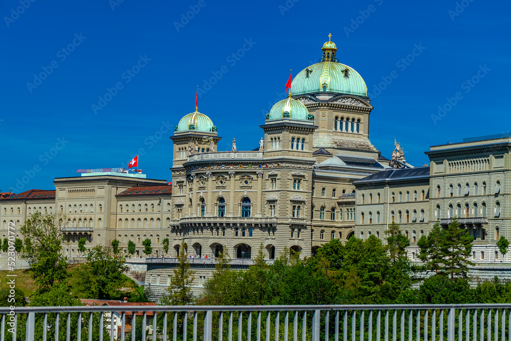 BERN, SWITZERLAND - August 2nd 2022: The Federal Palace of Switzerland (Bundeshaus) and River Aare in a beautiful summer day, Switzerland.