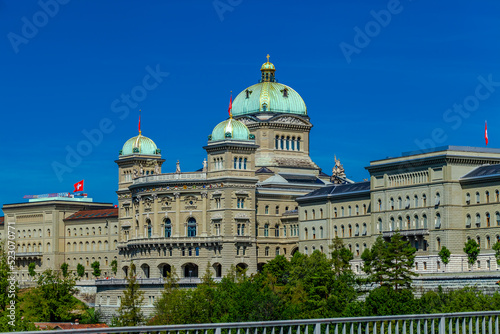 BERN, SWITZERLAND - August 2nd 2022: View on The Federal Palace of Switzerland (Bundeshaus) from the Kirchenfeld Bridge.