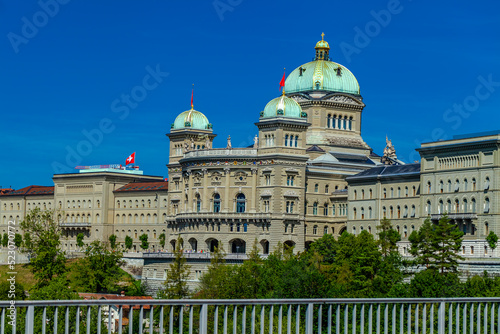 BERN, SWITZERLAND - August 2nd 2022: The Federal Palace of Switzerland (Bundeshaus) and River Aare in a beautiful summer day, Switzerland.