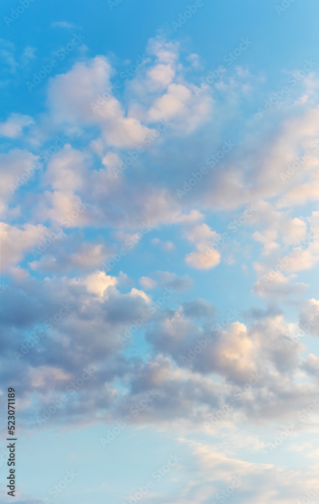 White clouds in the blue sky illuminated by the evening sun White clouds in the blue sky illuminated by the evening sun
