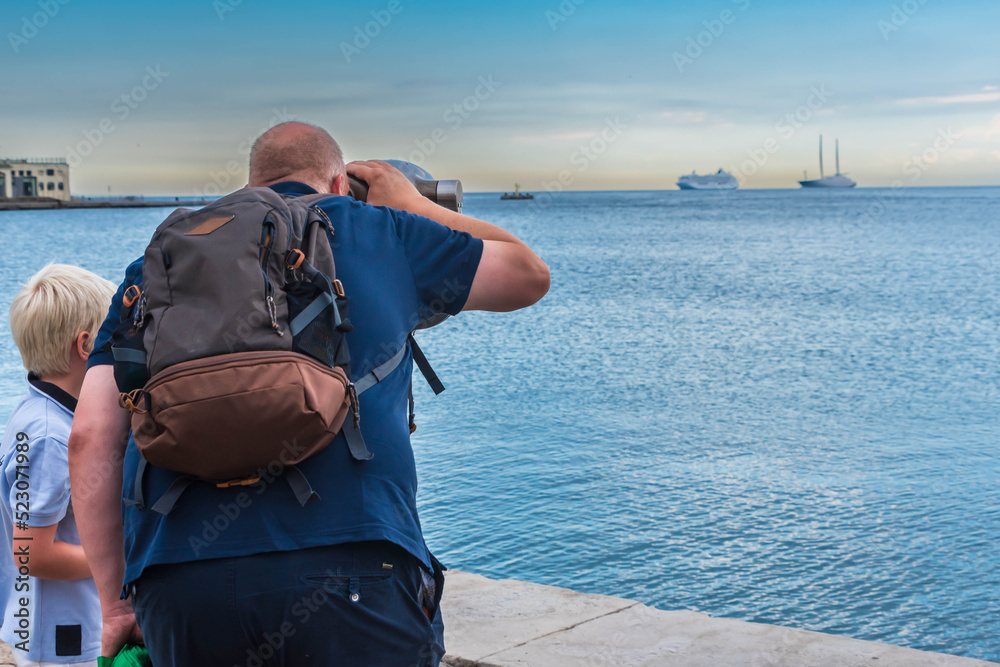Obraz premium person watching ships at the coastline in trieste, italy