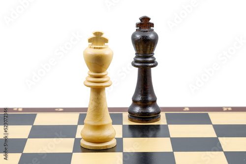 Two chess kings stand next to each other on a chessboard. Close-up. The concept of confrontation.