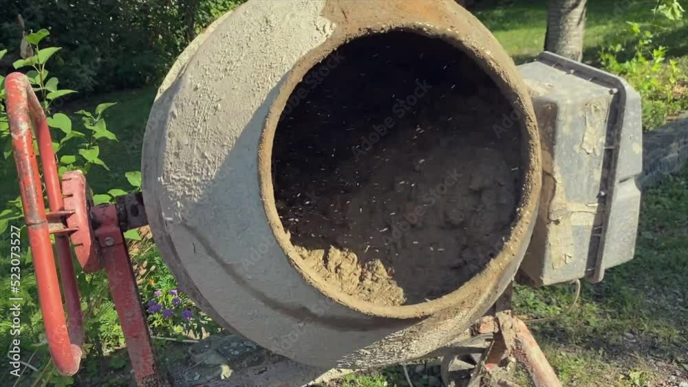 Concrete and crushed stone are mixed in a concrete mixer. Construction work Concrete and crushed stone are mixed in a concrete mixer. Construction work