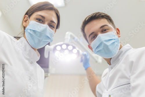 Portrait of female and male doctors during surgery and providing medical care. Dentistry help and care