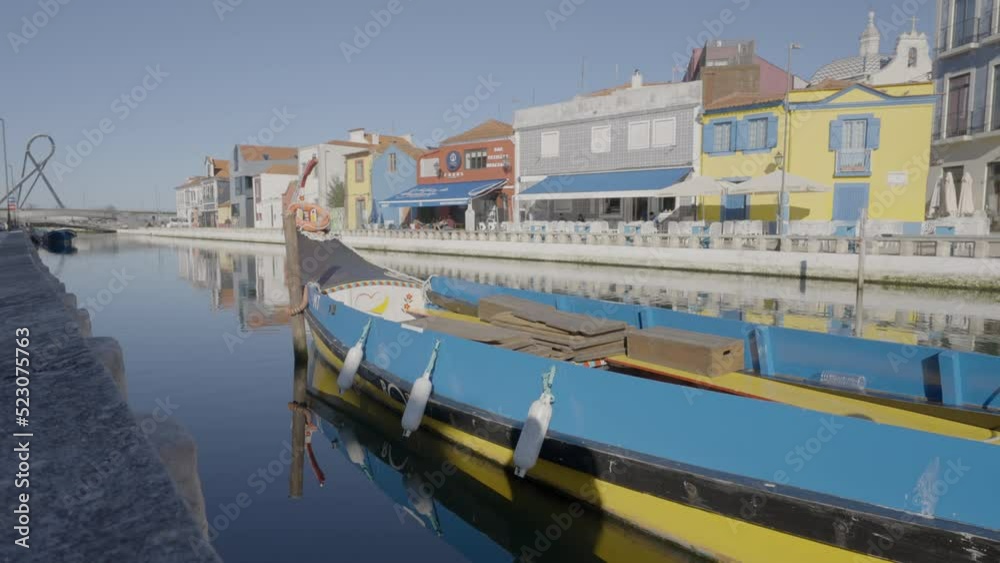 Blue Boat Moored On Tranquil River By Houses In City During Sunny Day - Lisbon, Portugal