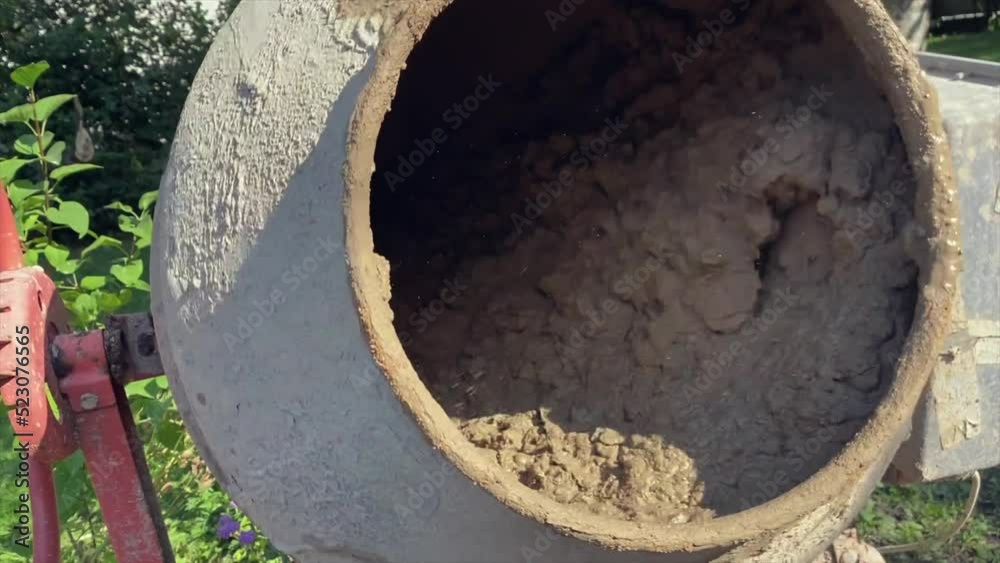 Concrete and crushed stone are mixed in a concrete mixer. Construction work Concrete and crushed stone are mixed in a concrete mixer. Construction work