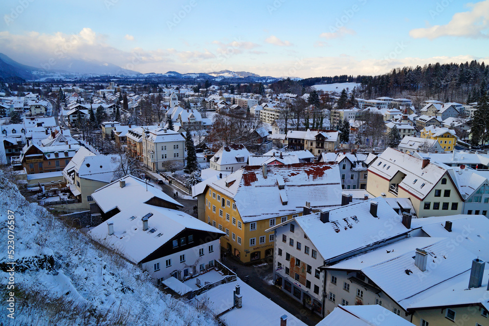 the wintery romantic ancient town of Fuessen in the scenic snowy Bavarian Alps with Forggensee in the background on a fine December day, Allgau, Bavaria, Germany